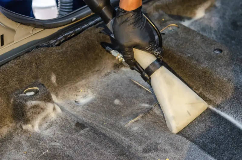 Extractor pulling dirt out of car carpet
