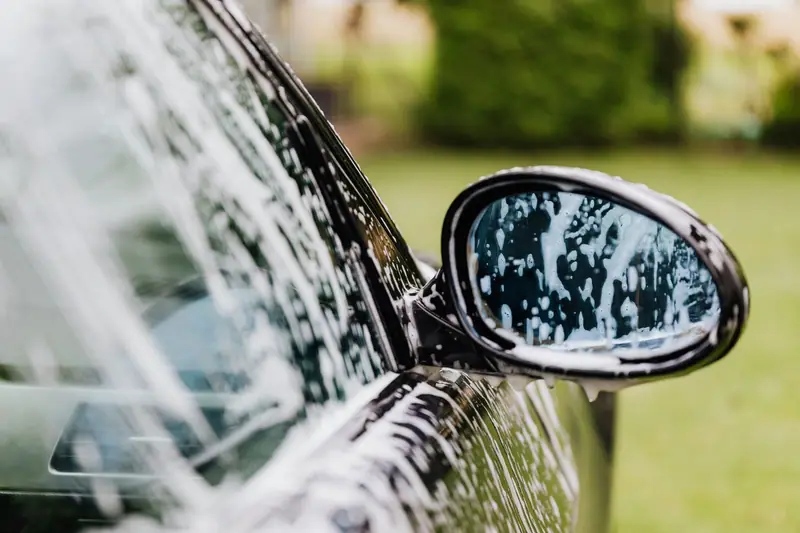 Foam on a car side mirror during a hand wash