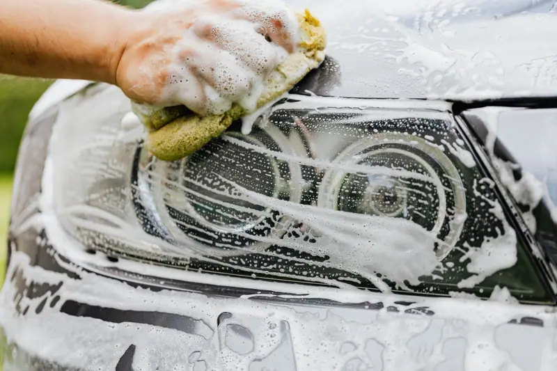 Hand wash mitt cleaning a headlight