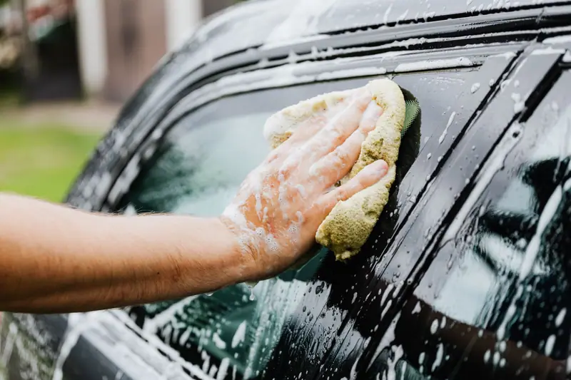 Wash mitt working foam across a car window