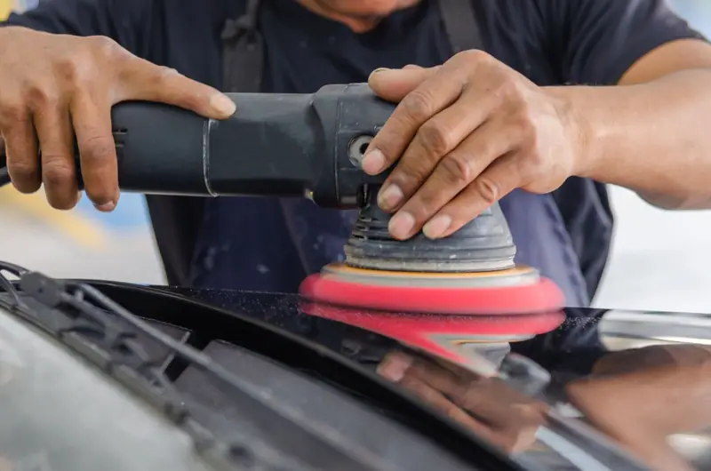 Machine polisher bringing back the gloss on car paint